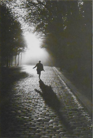 Atmospheric shot of a man running down a cobbled Street