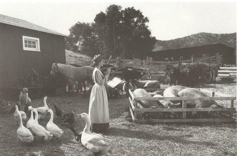 Woman in farmyard setting with farm animals (black & white)