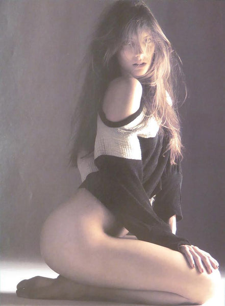 Brunette with long hair, kneeling in black & white jumper (Glamour)